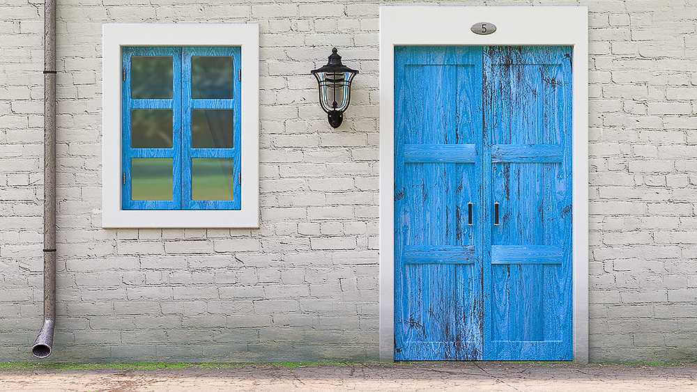Una puerta azul y una ventana en una casa antigua